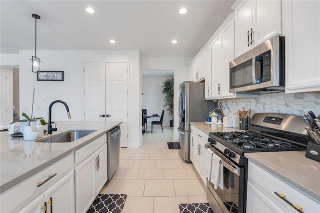 kitchen with white cabinets, appliances with stainless steel finishes, hanging light fixtures, and sink