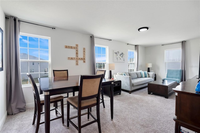 dining space with light colored carpet and a wealth of natural light