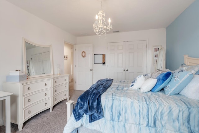 carpeted bedroom with a closet and a chandelier