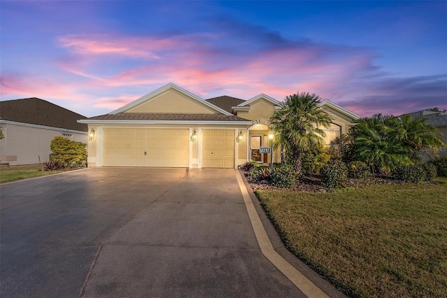 ranch-style home featuring a lawn and a garage