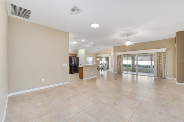 unfurnished living room with light tile patterned floors, vaulted ceiling, and ceiling fan