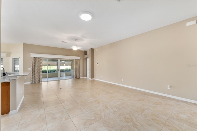 unfurnished living room featuring ceiling fan and sink