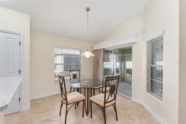 tiled dining room featuring vaulted ceiling