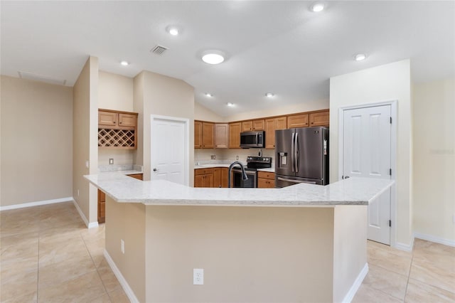 kitchen with light tile patterned floors, stainless steel appliances, vaulted ceiling, and a spacious island