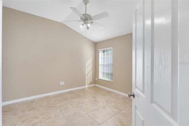 spare room with ceiling fan, light tile patterned floors, and vaulted ceiling