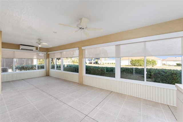 unfurnished sunroom with ceiling fan and a wall unit AC