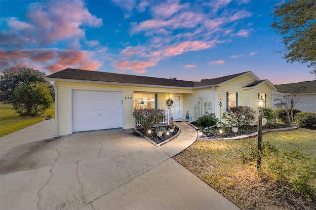 ranch-style home featuring a lawn and a garage