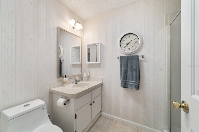 bathroom with vanity, tile patterned flooring, toilet, a textured ceiling, and walk in shower