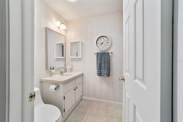 bathroom featuring vanity, a textured ceiling, tile patterned floors, and toilet