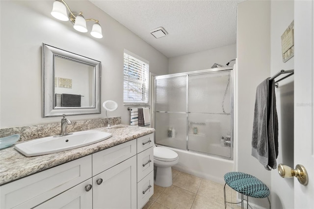 full bathroom featuring tile patterned flooring, enclosed tub / shower combo, a textured ceiling, toilet, and vanity