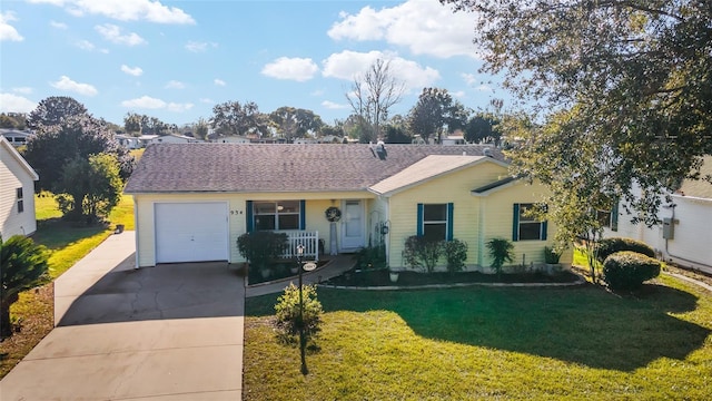 ranch-style house featuring covered porch, a front yard, and a garage