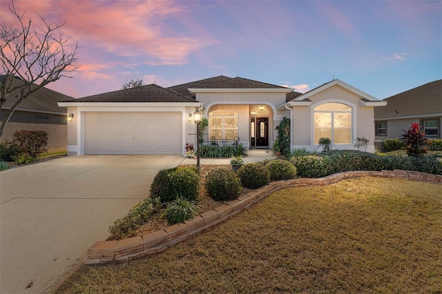 view of front of home with a garage and a lawn