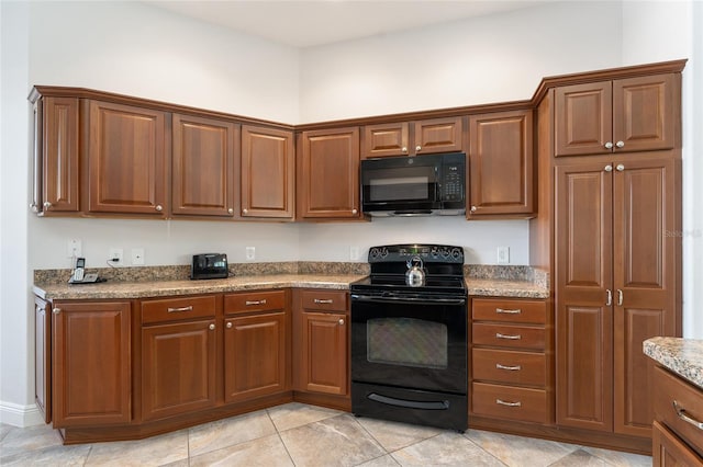 kitchen with black appliances, light tile patterned floors, and light stone countertops