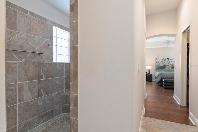 bathroom featuring ceiling fan, tile patterned floors, and tiled shower