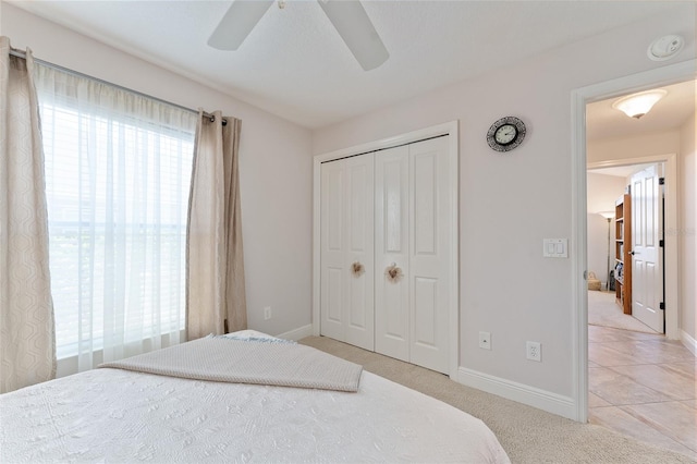 carpeted bedroom featuring ceiling fan and a closet