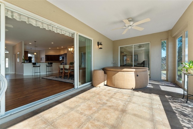 sunroom with ceiling fan with notable chandelier