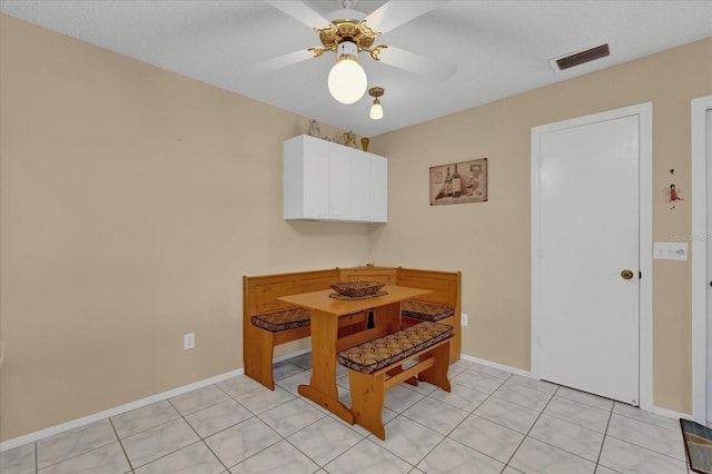 tiled dining room with ceiling fan and a textured ceiling