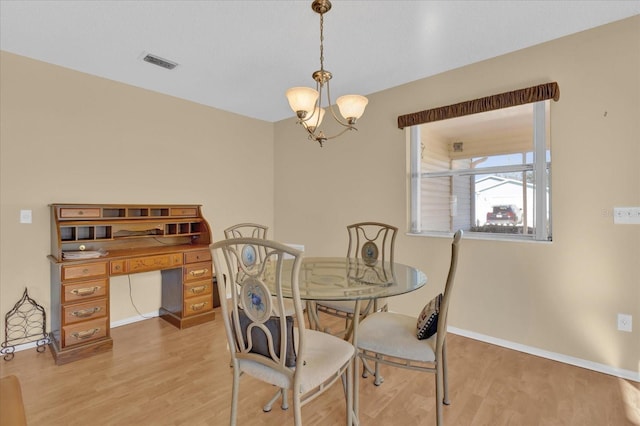 dining area featuring light hardwood / wood-style flooring and a chandelier