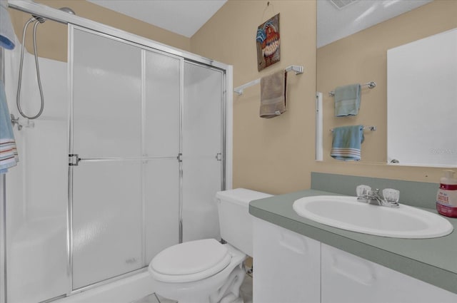 bathroom with vanity, a shower with shower door, a textured ceiling, and toilet