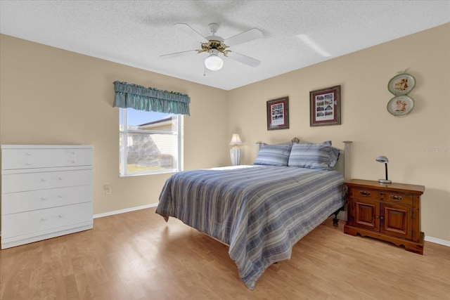 bedroom featuring ceiling fan, a textured ceiling, and light hardwood / wood-style flooring