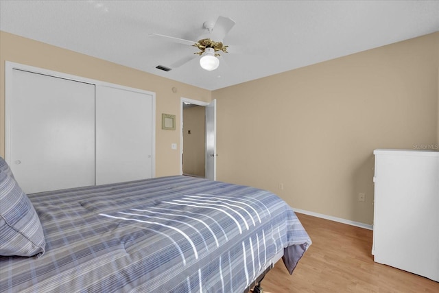 bedroom featuring ceiling fan, a closet, and light wood-type flooring