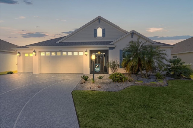 view of front of home featuring a garage and a yard