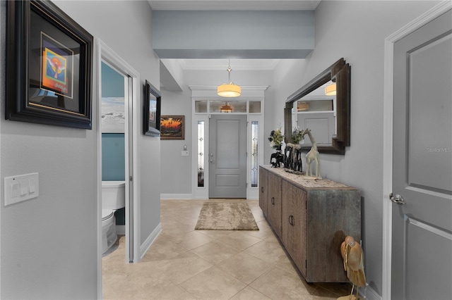 tiled entryway featuring crown molding