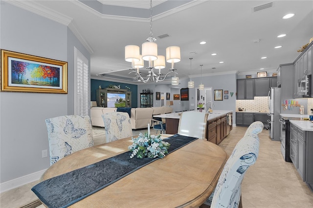 dining area featuring sink, crown molding, and a chandelier