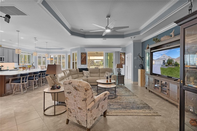 tiled living room featuring crown molding and a tray ceiling