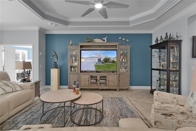 tiled living room featuring a raised ceiling, ceiling fan, and ornamental molding