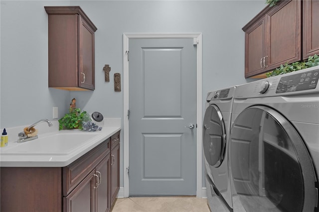 clothes washing area featuring washing machine and dryer, cabinets, light tile patterned flooring, and sink