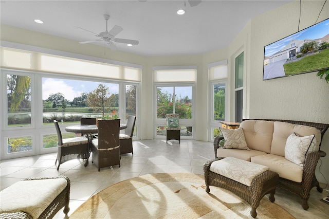 sunroom featuring a water view and ceiling fan