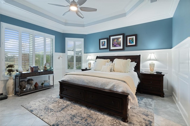 bedroom featuring ceiling fan, light tile patterned flooring, a tray ceiling, and ornamental molding