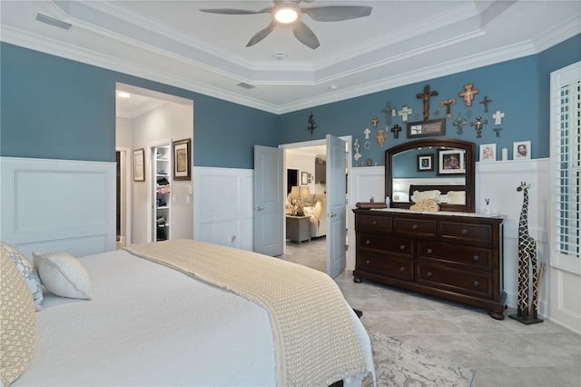 tiled bedroom featuring ceiling fan, a tray ceiling, and crown molding