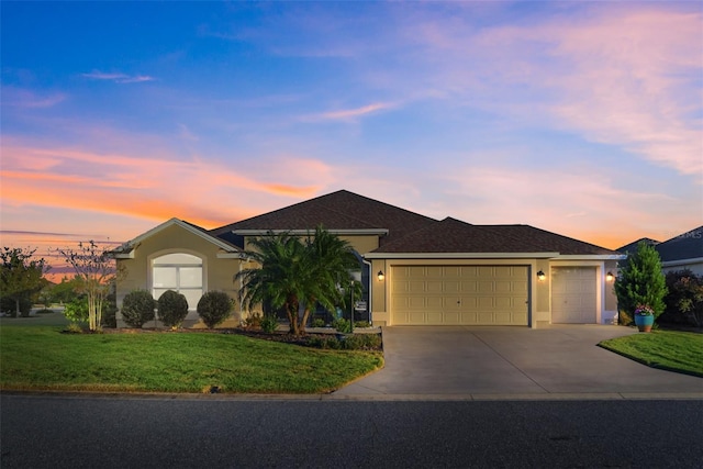 ranch-style house featuring a yard and a garage