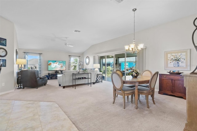 carpeted dining space featuring vaulted ceiling, plenty of natural light, and ceiling fan with notable chandelier