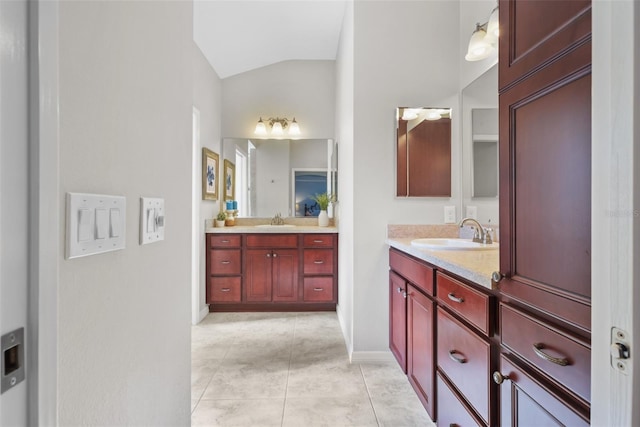 bathroom featuring tile patterned flooring, vanity, and vaulted ceiling