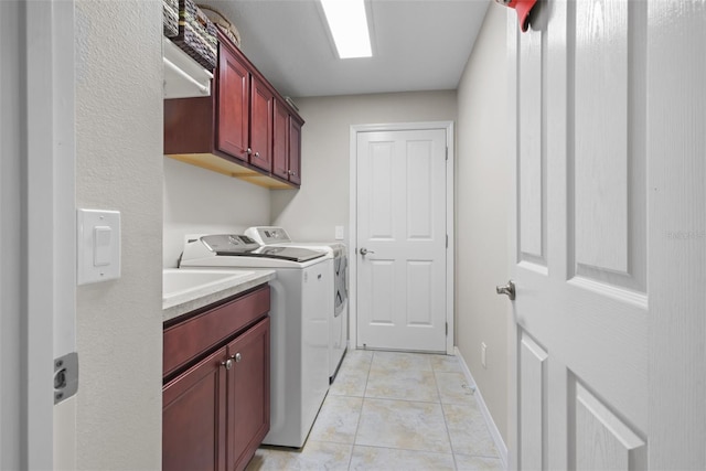 laundry area with washer and clothes dryer, light tile patterned floors, and cabinets