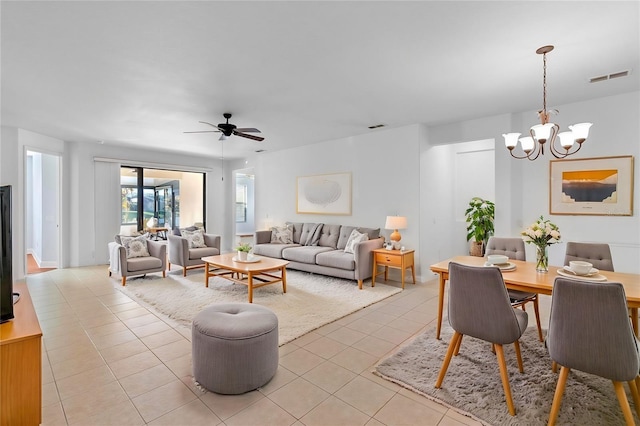 tiled living room featuring ceiling fan with notable chandelier