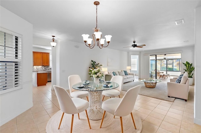 dining area with ceiling fan with notable chandelier and light tile patterned flooring