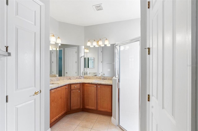 bathroom featuring tile patterned floors, vanity, and a shower with shower door