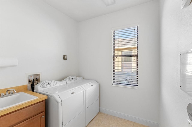 clothes washing area with cabinets, sink, light tile patterned flooring, and washer and dryer