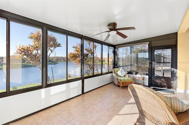 sunroom with ceiling fan, a water view, and a healthy amount of sunlight