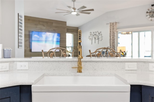 kitchen with sink, vaulted ceiling, ceiling fan, decorative backsplash, and blue cabinetry