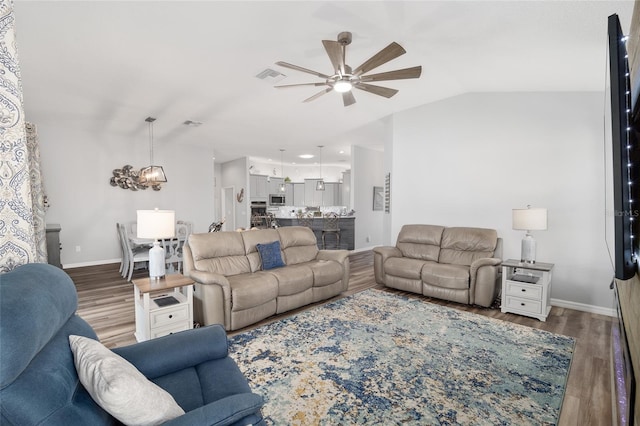 living room with lofted ceiling, wood-type flooring, and ceiling fan