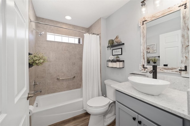 full bathroom featuring toilet, hardwood / wood-style flooring, shower / tub combo with curtain, and vanity