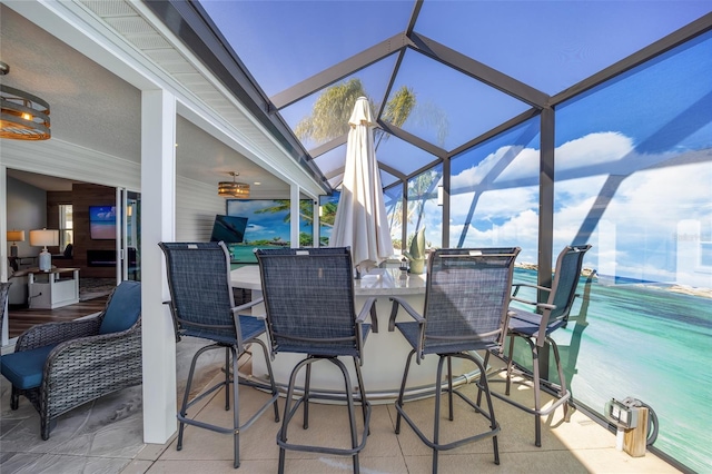 view of patio / terrace featuring a bar and glass enclosure