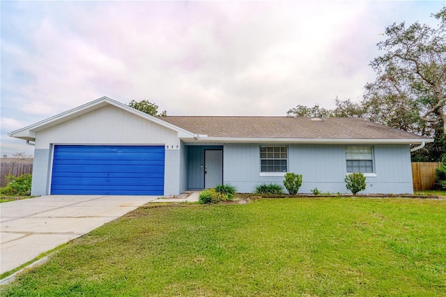 ranch-style home featuring a garage and a front lawn