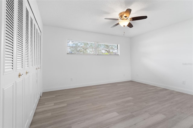 unfurnished bedroom with ceiling fan and light hardwood / wood-style floors