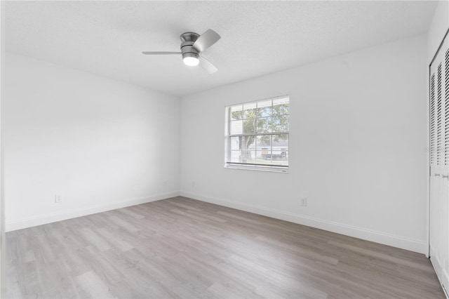 spare room featuring a textured ceiling, light hardwood / wood-style flooring, and ceiling fan